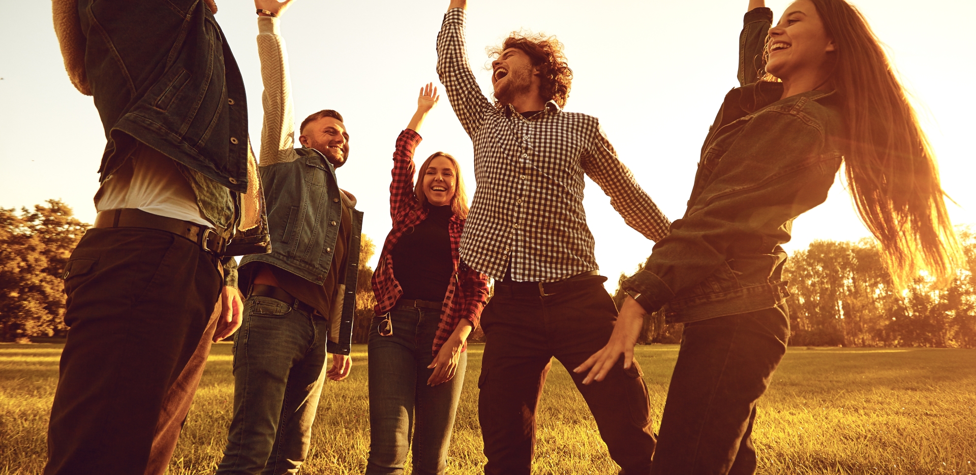 A group of friends celebrating with their hands in the air.