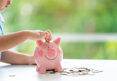 A child puts coins in the piggy bank
